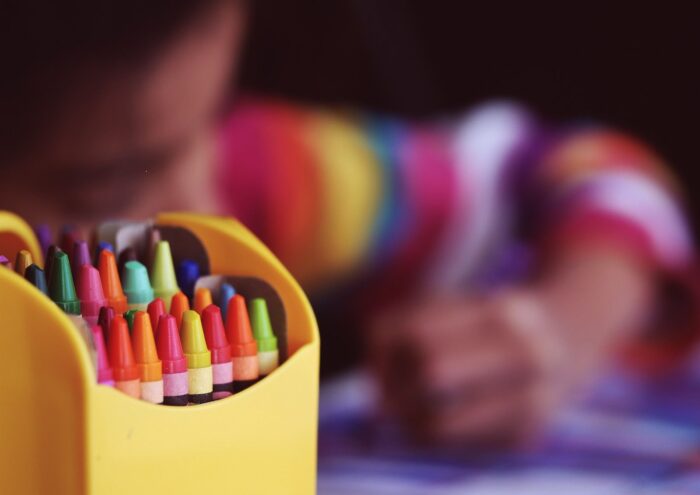 Premier plan crayons de couleur, arrière plan enfant qui dessine